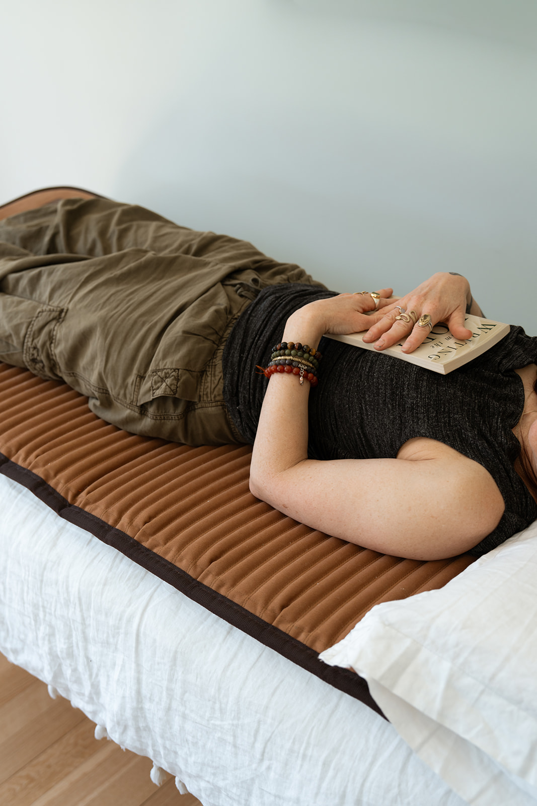 A woman resting on a bodywork mat, embodying somatic stillness.