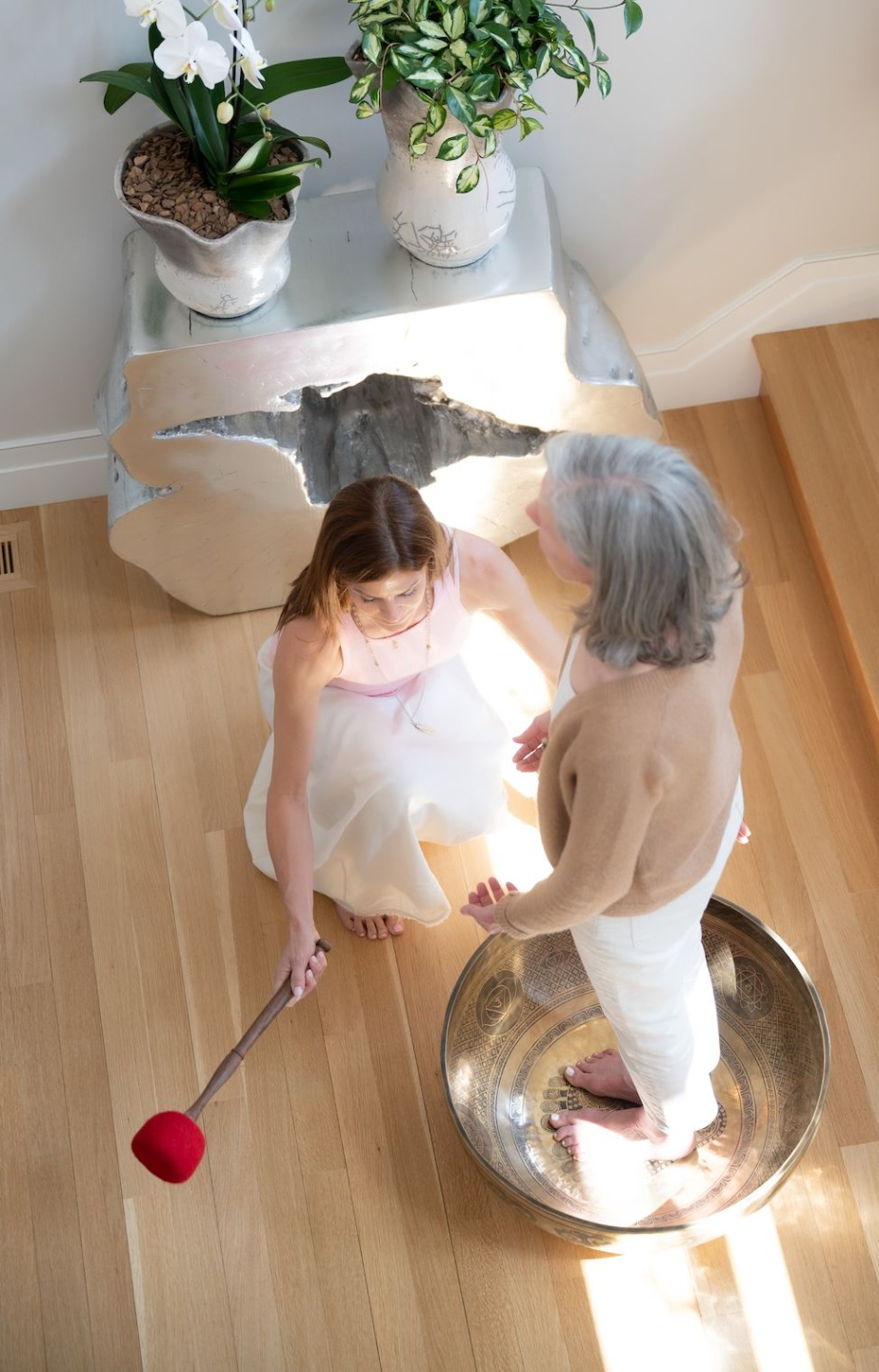 A guest standing inside a large alchemy crystal singing bowl.
