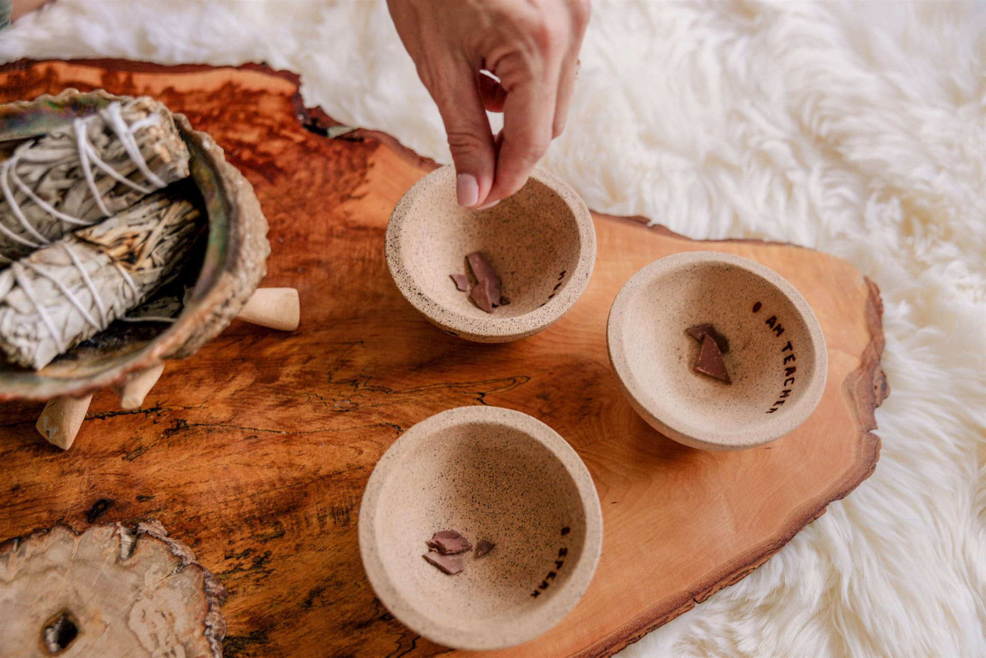 Small ceramic bowls with cacao on a live-edge wooden tray, prepared for ceremony.
